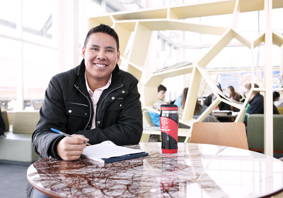 A student looks at the camera while studying in the Taylor Family Digital Library.