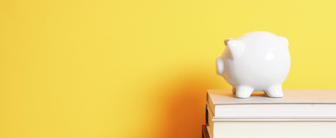 a piggy bank on top of a pile of books