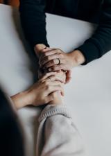 people holding hands across a table